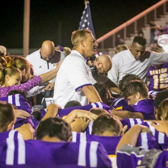 Benton Football Coach praying with students