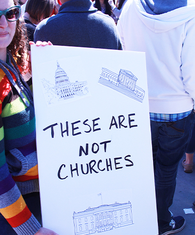 Women holds pro church-state separation sign at rally.