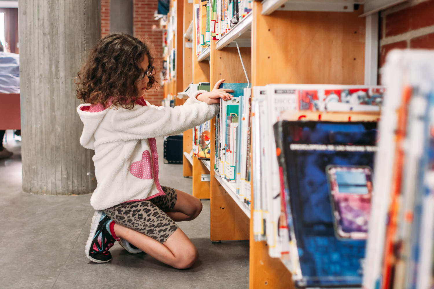 Child searching for books at a library