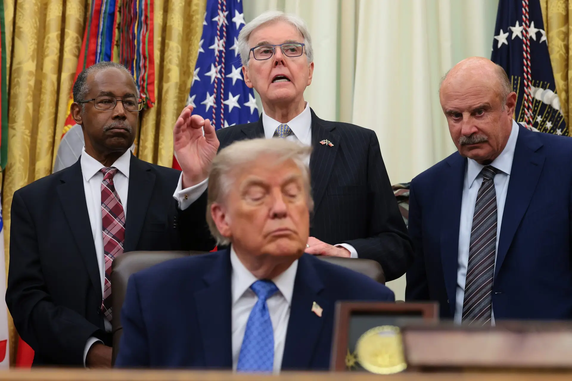 Religious Liberty Commission Chairman and Texas Lt. Gov. Dan Patrick (center) speaks alongside President Donald Trump and RLC members Dr. Ben Carson (left) and Dr. Phil McGraw during an event in the White House on June 26, 2026, in Washington, D.C. (Photo by Anna Moneymaker/Getty Images)