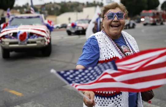 A participant waves an American flag during the 67th annual El Sereno Independence Day Parade in the predominantly Latino community of El Sereno on June 27, 2026, in Los Angeles, California. It was held as communities across the country are celebrating America's 250th anniversary. (Photo by Mario Tama/Getty Images)